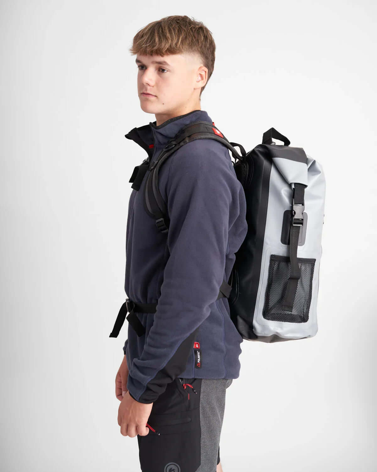 Sac à dos imperméable 35L porté par un homme en pull, présentant son design robuste et fonctionnel.
