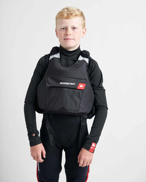 Gilet de sauvetage Rooster® Diamond Junior porté par un jeune garçon en tenue de voile et kayak.