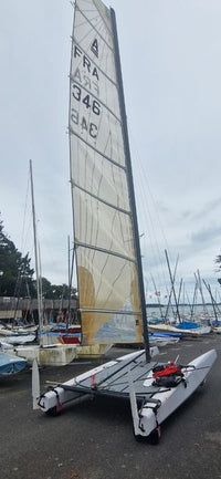 Bimare V1 Classe A bateau d'occasion, élégant et prêt à naviguer sur le port avec voiles déployées.