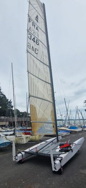 Bimare V1 Classe A bateau d'occasion, élégant et prêt à naviguer sur le port avec voiles déployées.