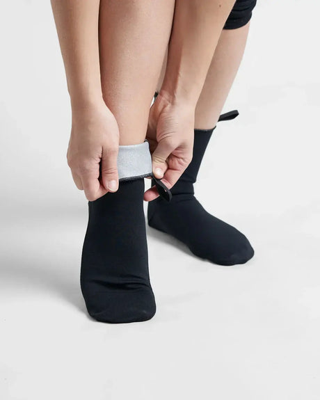 Chaussettes Hot Socks 0.5mm portées sur des pieds, ajustant le renfort à la cheville.