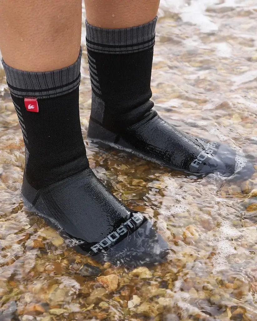 Chaussettes imperméables Rooster portées dans l'eau, offrant protection contre l'humidité et le froid.