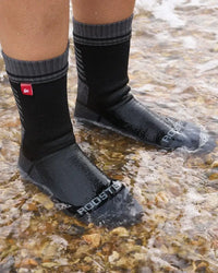 Chaussettes imperméables Rooster portées dans l'eau, offrant protection contre l'humidité et le froid.