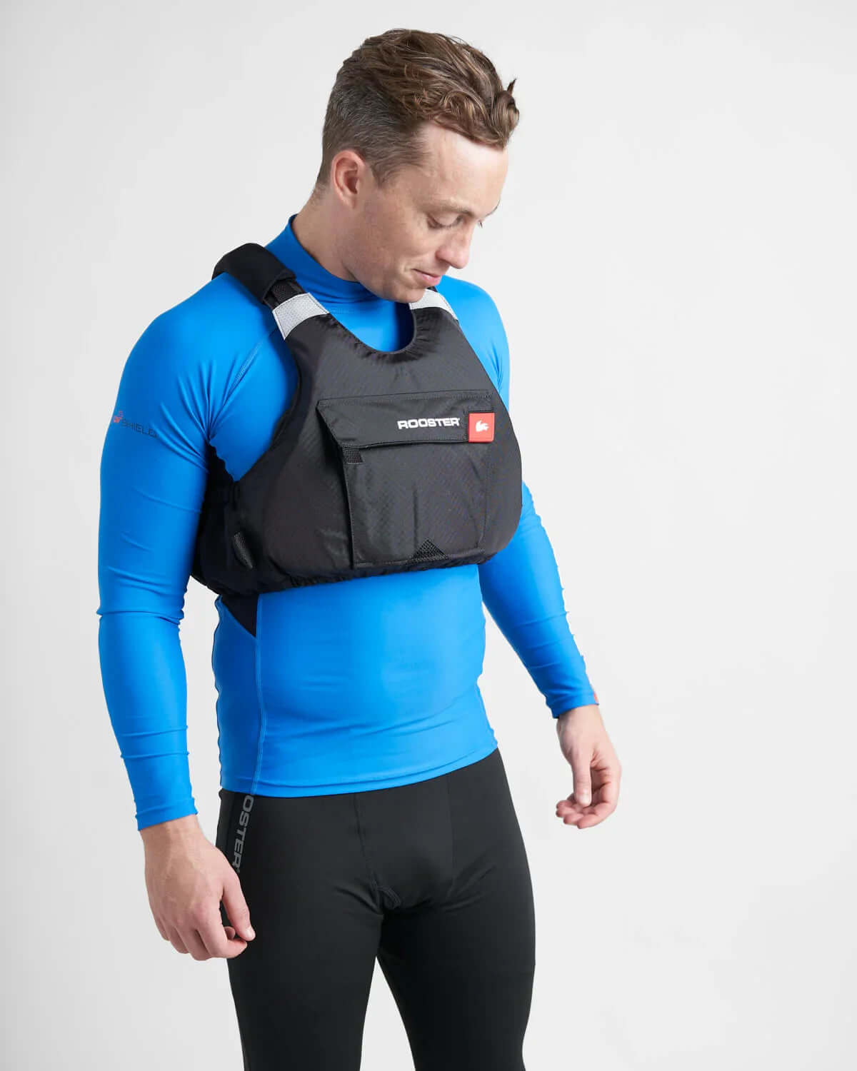 Gilet de sauvetage Rooster® Diamond porté par un homme en tenue de surf, illustrant son design ergonomique.