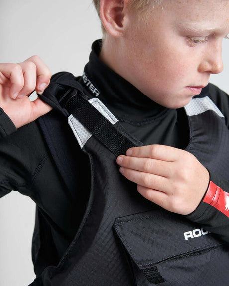 Enfant ajustant le gilet de sauvetage Rooster® Diamond Junior, coupe confortable et pratique pour voile.