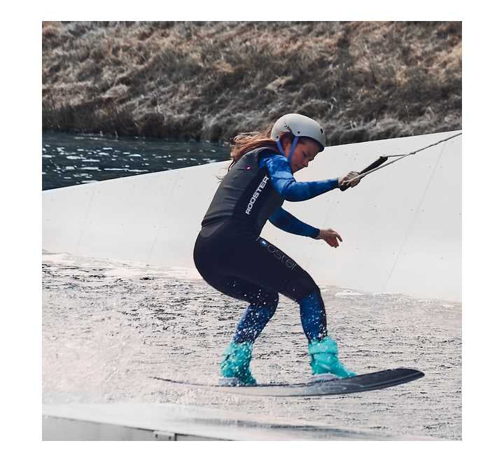 Femme en action sur une planche avec le Long John Thermaflex 1.5mm femme dans un environnement aquatique.