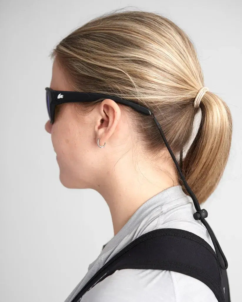 Femme portant des lunettes sport polarisées avec une monture TR90 robuste et un design élégant.