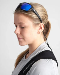 Lunettes sport polarisées portées par une femme, monture TR90 et verres polarisés réfléchissants.