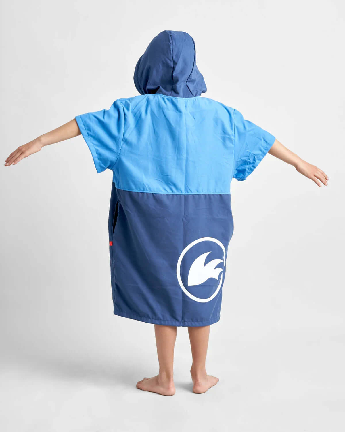 Poncho Junior microfibres porté par un enfant, vue arrière, couleur bleu et bleu marine, conçu pour le confort après les activités nautiques.