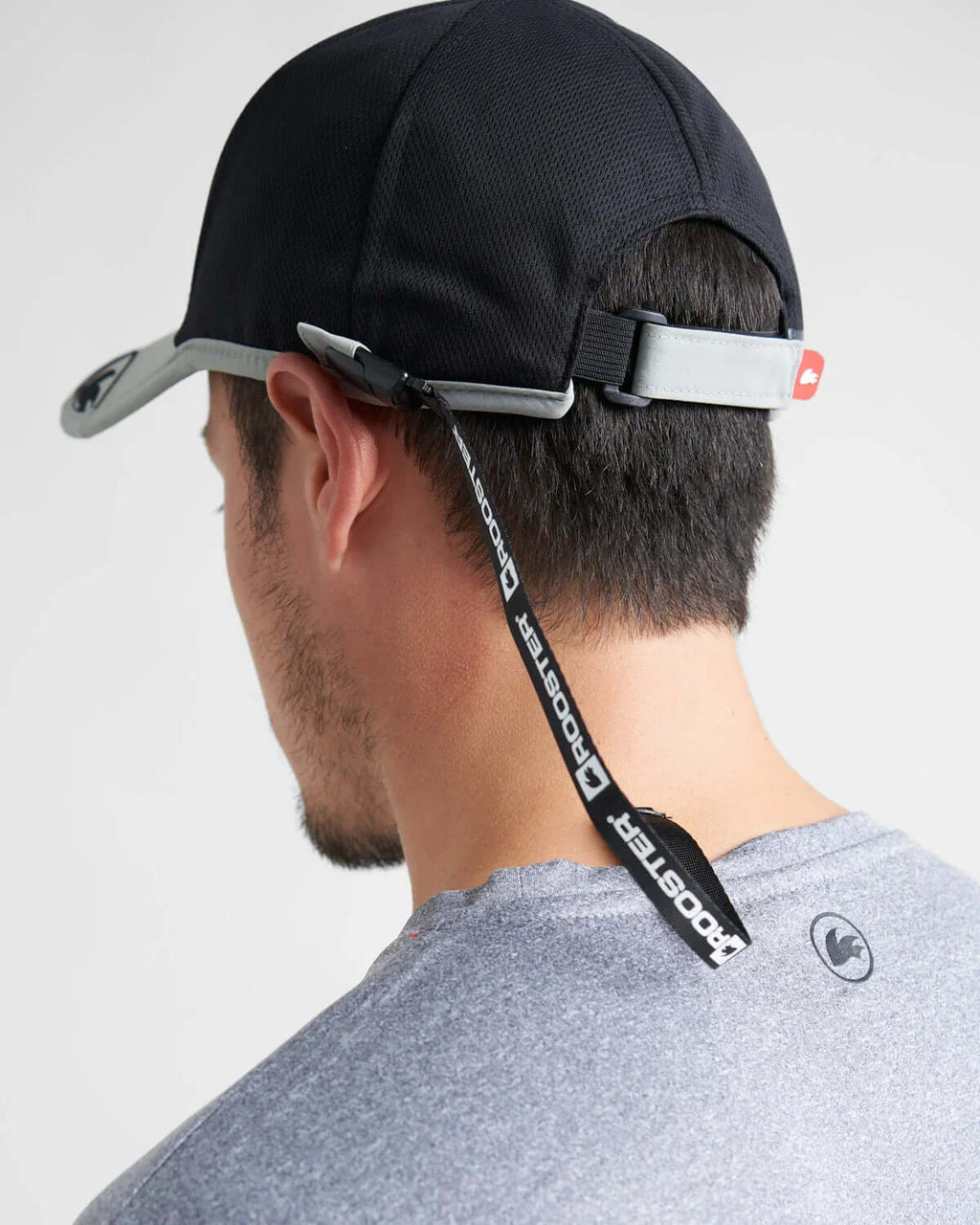 Homme portant une casquette avec un Leash casquette Rooster fixé à l'arrière pour sécurité.