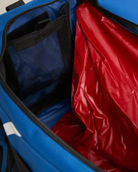 Intérieur du sac multifonctions 90L avec compartiment étanche et poches en filet.