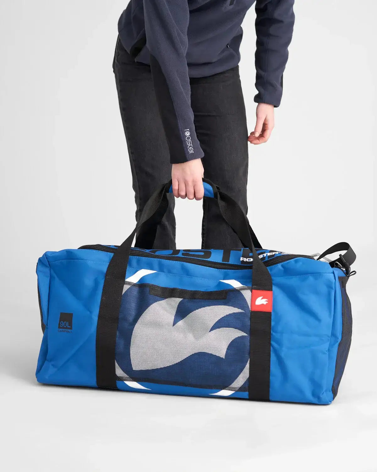 Sac multifonctions 90L en bleu, porté à la main, idéal pour le rangement d'équipement.