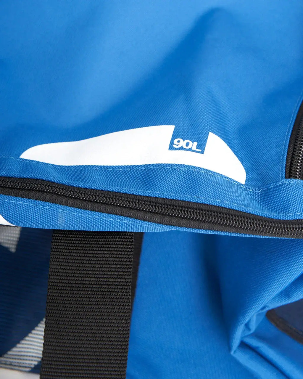 Détail du sac multifonctions 90L avec un zip et une étiquette indiquant "90L" en bleu