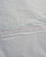 Surface étanche d'un Taud du dessus ILCA avec gouttes d'eau, illustrant ses propriétés imperméables et respirantes.