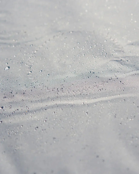 Surface étanche d'un Taud du dessus ILCA avec gouttes d'eau, illustrant ses propriétés imperméables et respirantes.