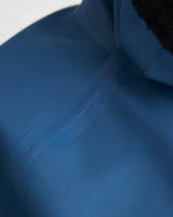 Détail du haut Top Pro Aquafleece Women montrant une couture étanche sur un tissu imperméable.
